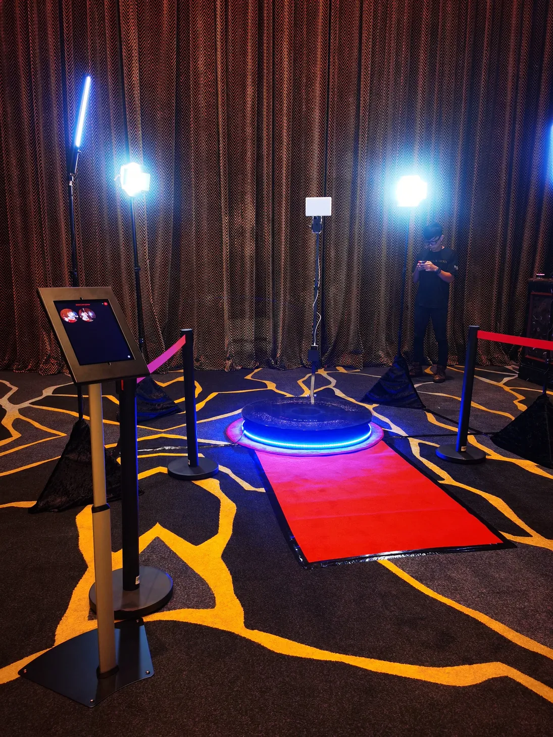 360 video booth platform with studio lights, queue stands and a red carpet, set up at an event