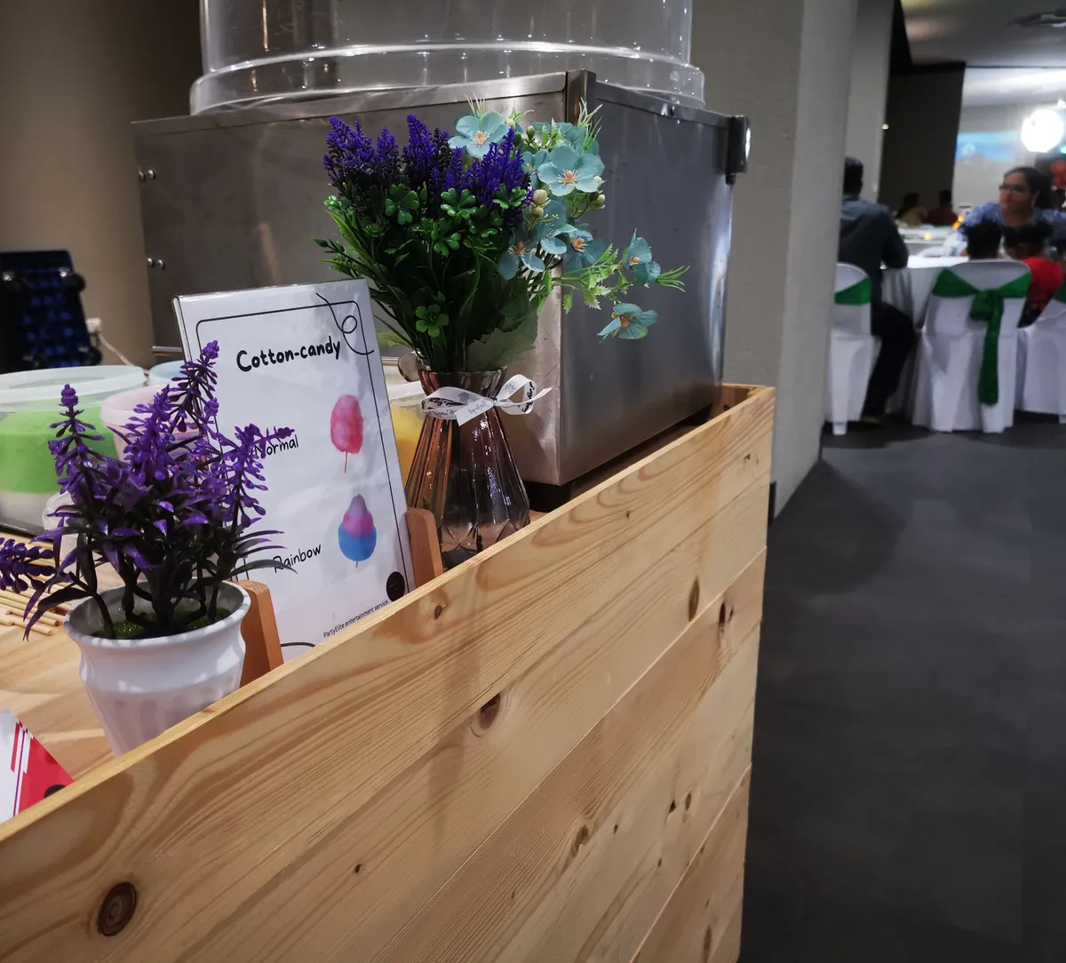 Candy booth counter with a cotton candy machine at an indoor event