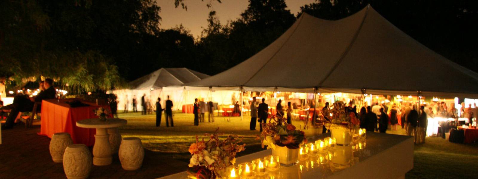 Outdoor event lighting aimed across a covered event floor