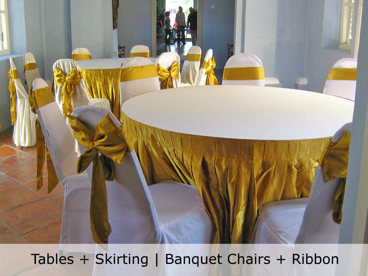 Round tables with skirting, banquet chairs and ribbons set up by TentHouz