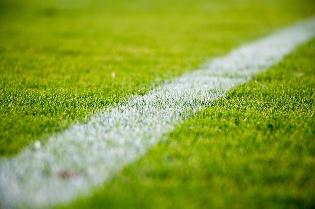 Artificial grass carpet rolled out over concrete flooring for an event