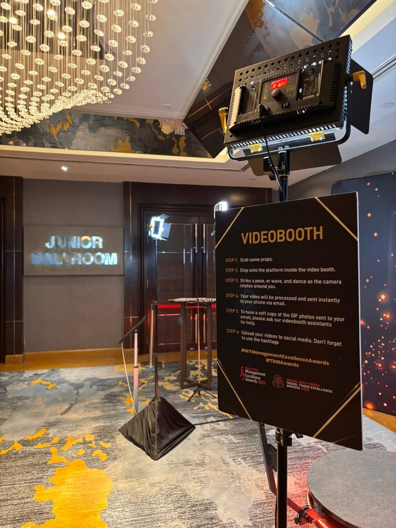 Instruction sign beside a 360 video booth listing the steps for guests, with an LED panel light on a stand behind it